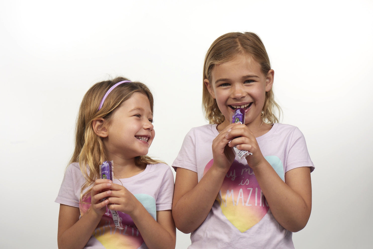 Two girls enjoying blueberry popsicles