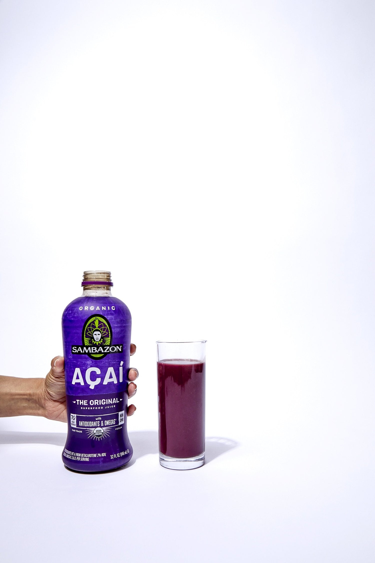 acai juice bottle and cup filled with deep purple drink